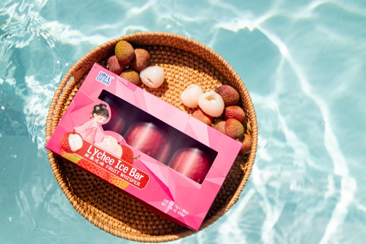 Deshi Lychee box and lychees in a basket beside the pool