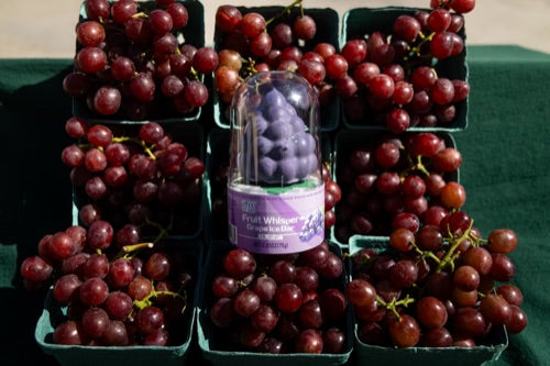 Deshi Grape ice bar in its individual packaging among grapes